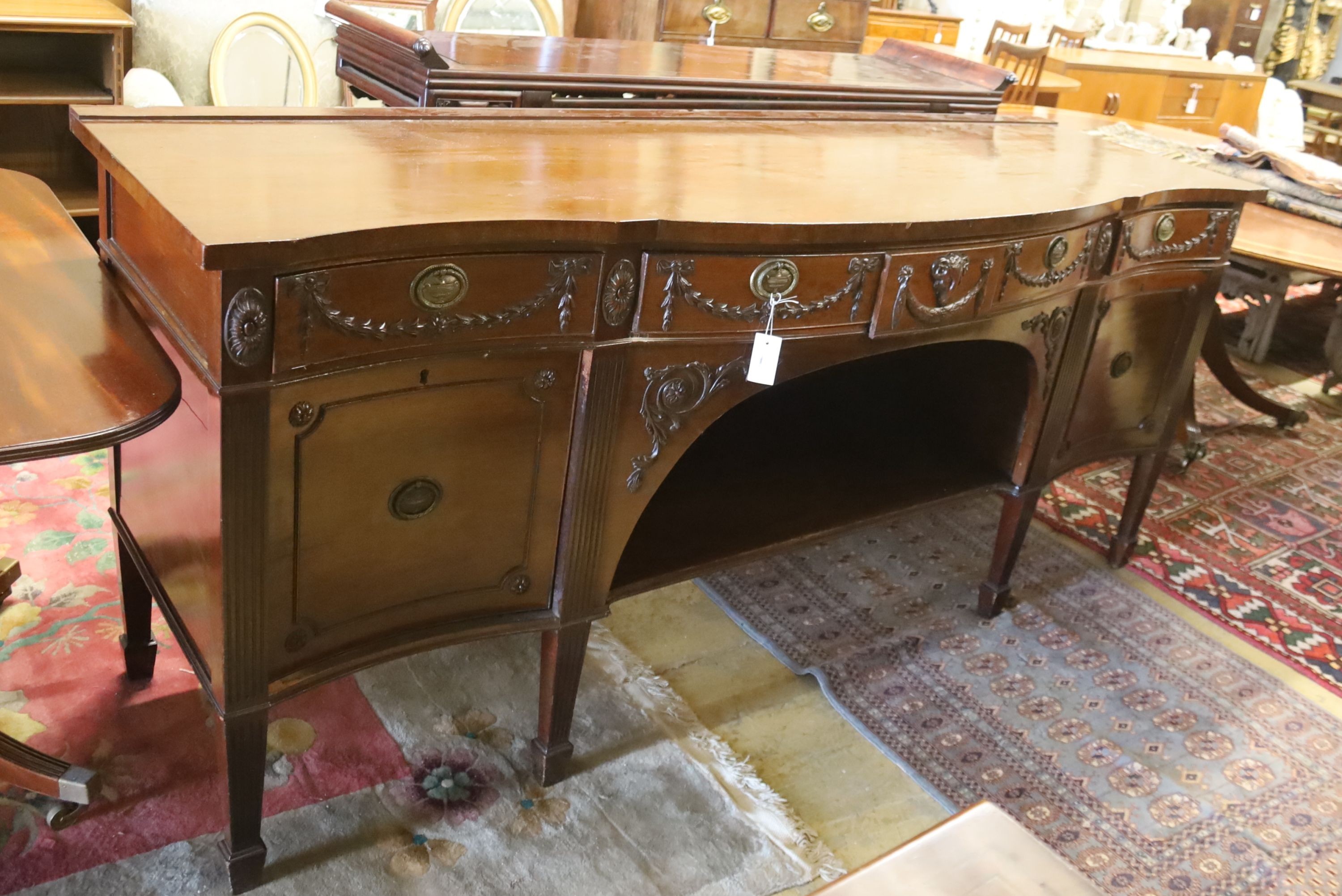 An early 20th century Adam design mahogany serpentine sideboard, length 214cm, depth 68cm, height 92cm